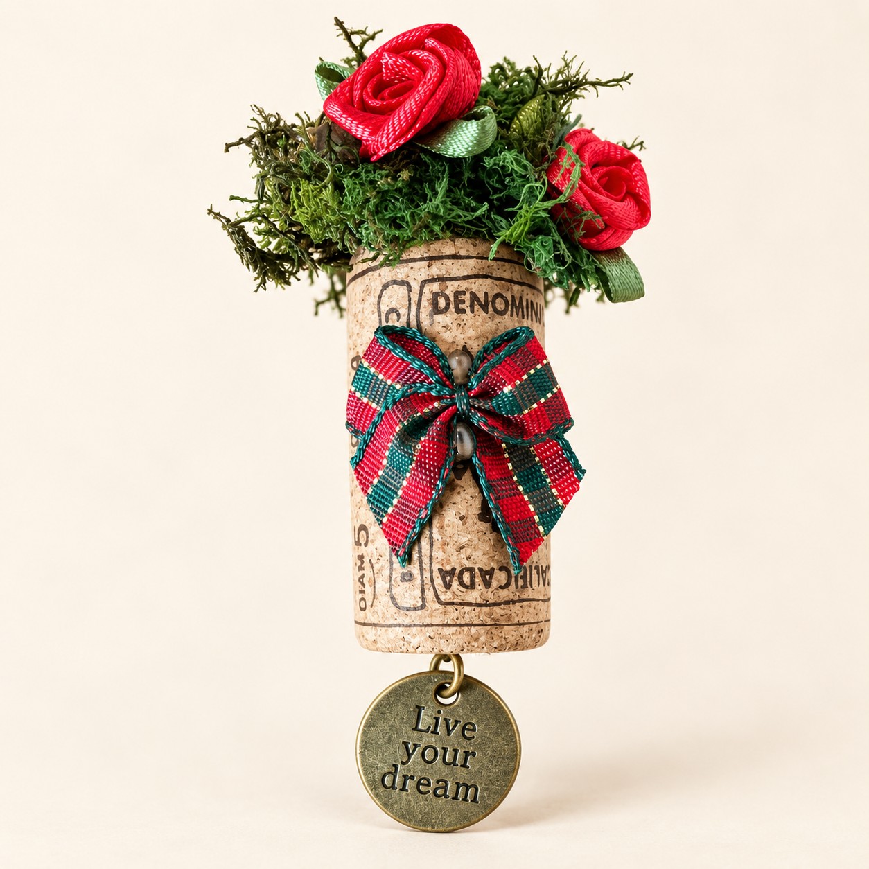 a wine cork magnet with red roses, a tartan bow and a round Live your dream charm